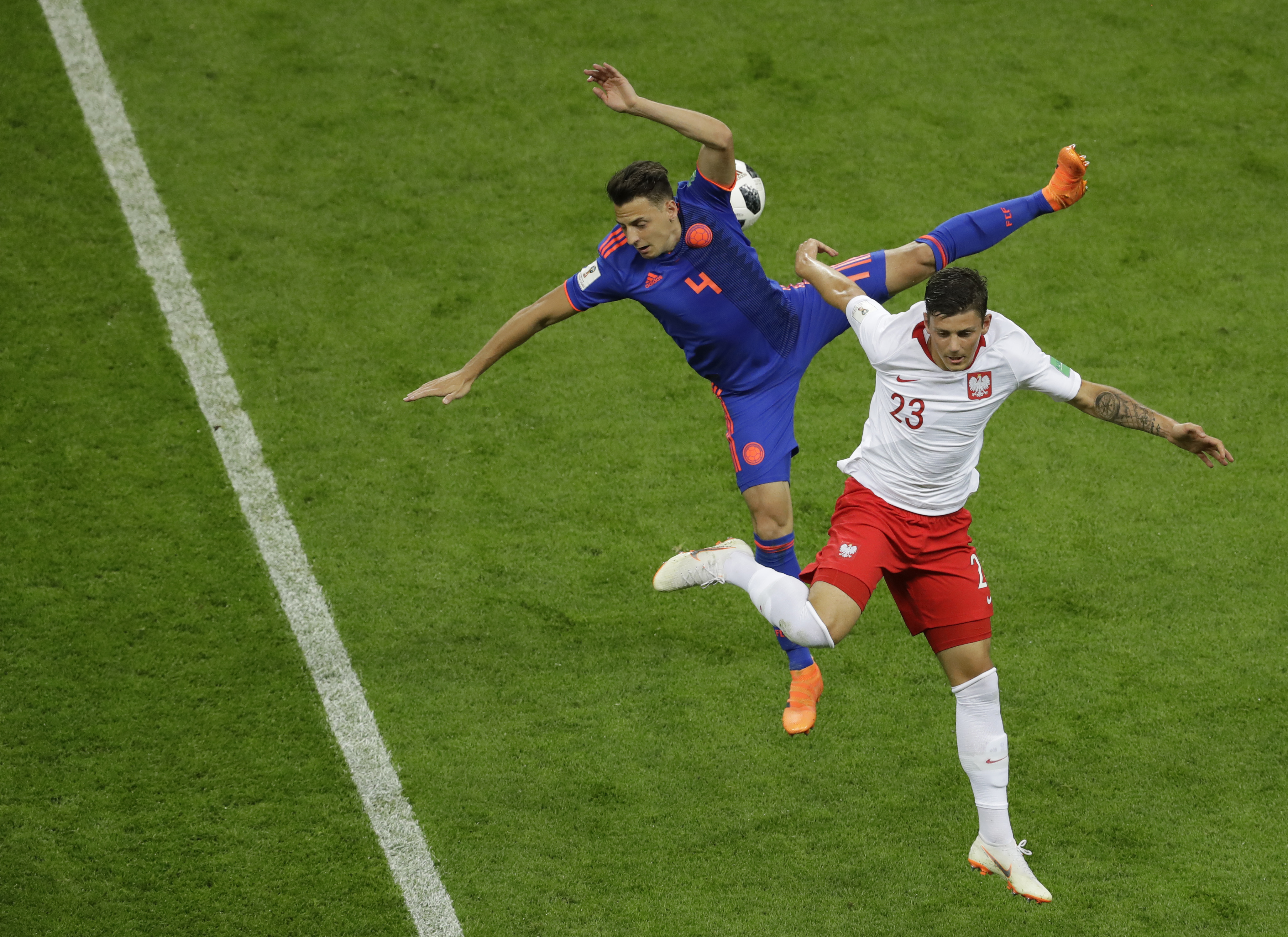 <div class='meta'><div class='origin-logo' data-origin='none'></div><span class='caption-text' data-credit='Sergei Grits/AP Photo'>Colombia's Santiago Arias, left, and Poland's Dawid Kownacki battle for the ball during the group H match at the Kazan Arena in Kazan, Russia, Sunday, June 24, 2018.</span></div>