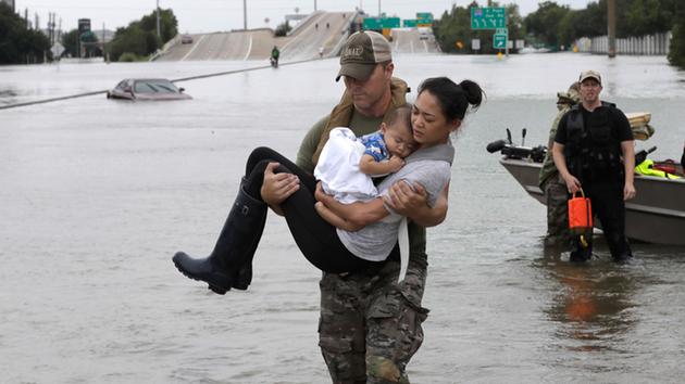 <div class='meta'><div class='origin-logo' data-origin='none'></div><span class='caption-text' data-credit='David J. Phillip/AP Photo'>Houston Police SWAT officer Daryl Hudeck carries Catherine Pham and her 13-month-old son Aiden after rescuing them from their home surrounded by floodwaters.</span></div>