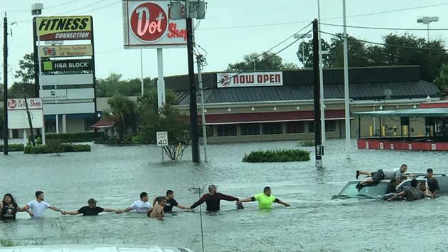 <div class='meta'><div class='origin-logo' data-origin='none'></div><span class='caption-text' data-credit='M. Alvarez'>A human chain is formed during a rescue operation at I-10 and Federal Road in Houston.</span></div>