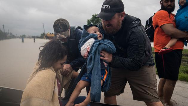 <div class='meta'><div class='origin-logo' data-origin='none'></div><span class='caption-text' data-credit='Jabin Botsford/The Washington Post via Getty Images'>Glenda Montelongeo, Richard Martinez and his two sons are helped out of a boat after being rescued near Tidwell Road and Toll road 8 in Houston, TX on Tuesday.</span></div>