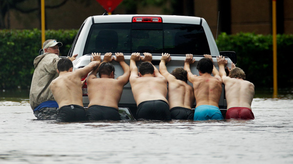 <div class='meta'><div class='origin-logo' data-origin='none'></div><span class='caption-text' data-credit='Charlie Riedel/AP Photo'>People push a stalled pickup through a flooded street in Houston, after Tropical Storm Harvey dumped heavy rains, Sunday, Aug. 27, 2017.</span></div>