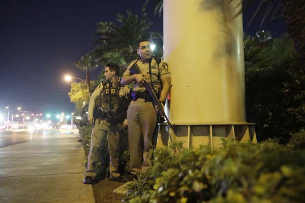 <div class='meta'><div class='origin-logo' data-origin='AP'></div><span class='caption-text' data-credit='AP'>Police officers take cover near the scene of a shooting near the Mandalay Bay resort and casino on the Las Vegas Strip, Sunday, Oct. 1, 2017, in Las Vegas. (AP Photo/John Locher)</span></div>