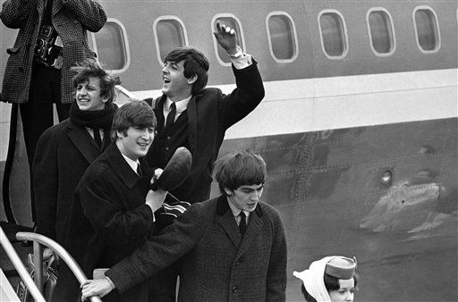 The Beatles make a windswept arrival on Feb. 7, 1964, as they step down from the plane that brought them from London, at Kennedy airport. <span class=meta>AP Photo</span>