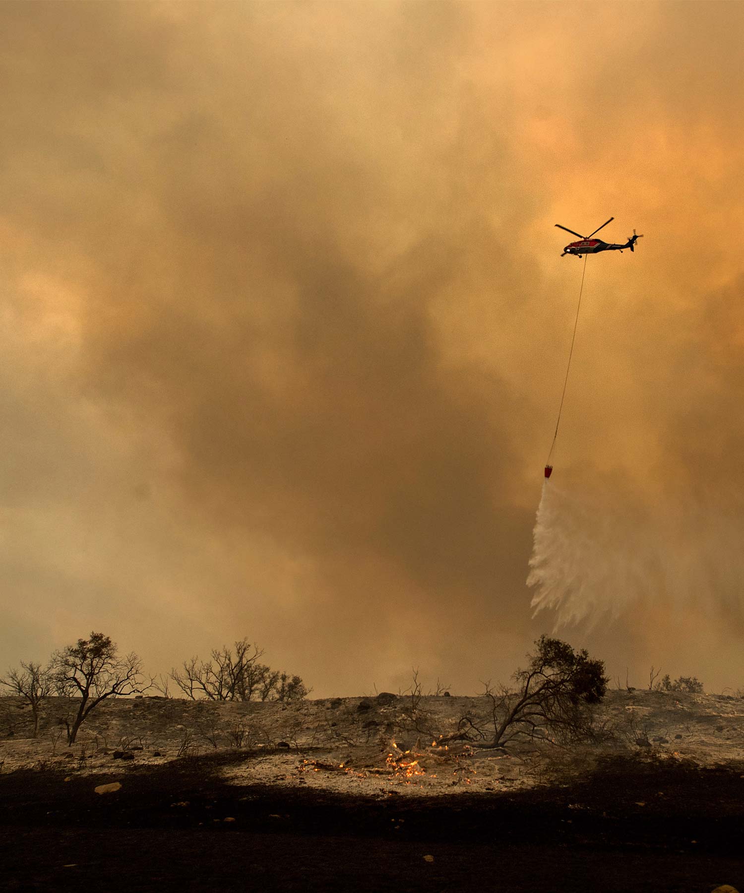 <div class='meta'><div class='origin-logo' data-origin='AP'></div><span class='caption-text' data-credit='AP Photo/Noah Berger'>A helicopter drops water while trying to keep a wildfire from jumping Santa Ana Road near Ventura, Calif., on Saturday, Dec. 9, 2017.</span></div>