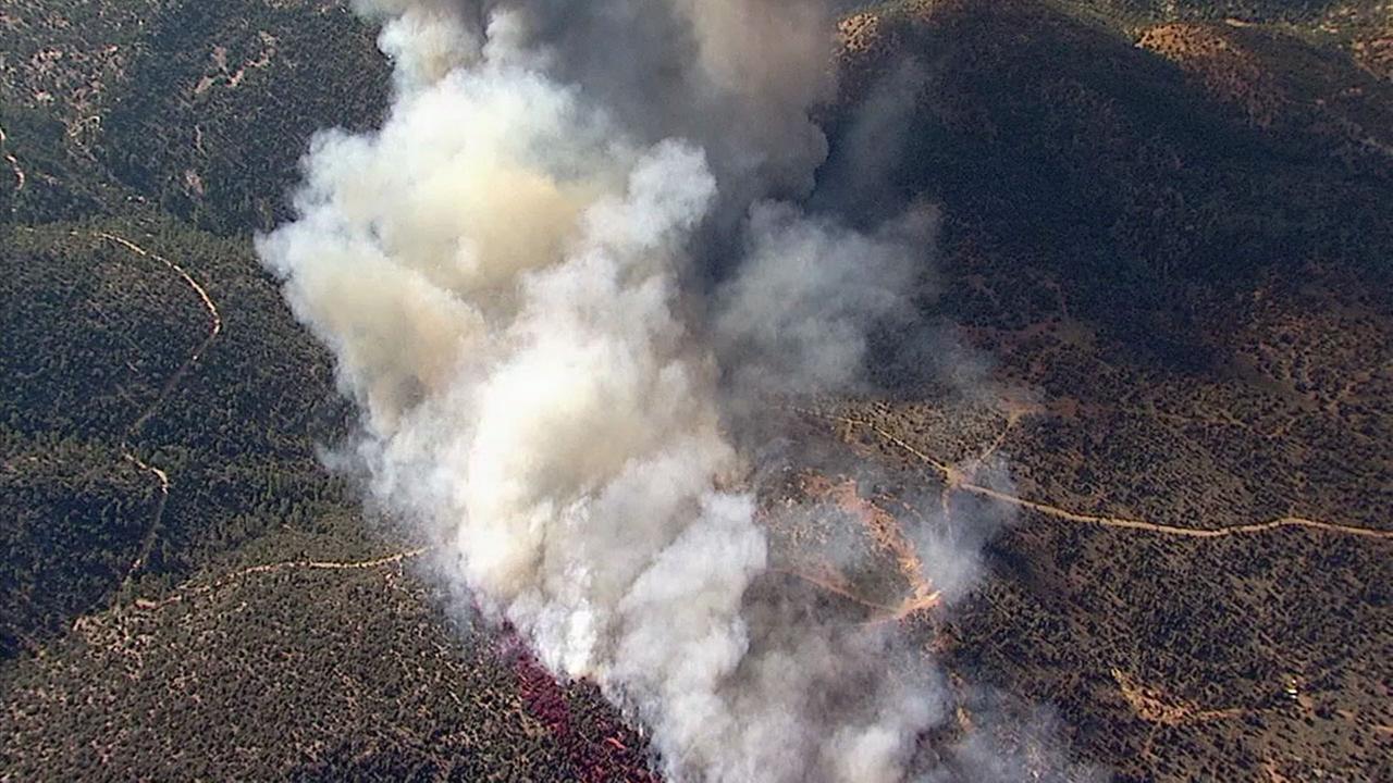 Smoke billows from the mountainsides in Big Bear as a large brush fire burns on Monday