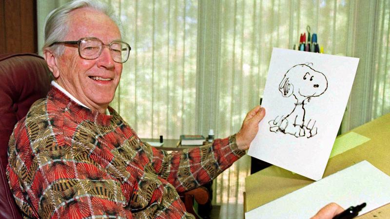 Cartoonist Charles Schulz displays a sketch of his beloved character Snoopy in his office in Santa Rosa, Calif. in 1997.