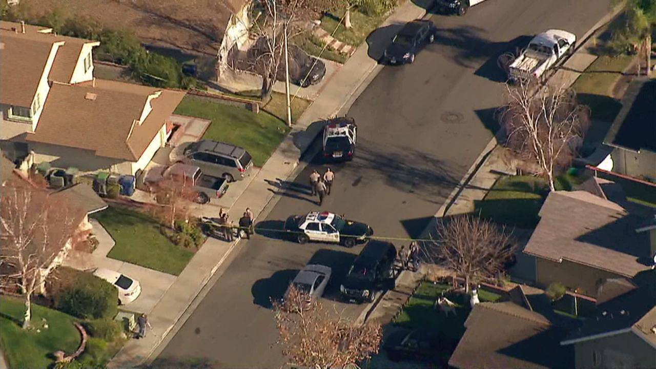 Authorities surround a Santa Clarita home where four people were found dead from a shooting on Friday, Jan. 5, 2018.