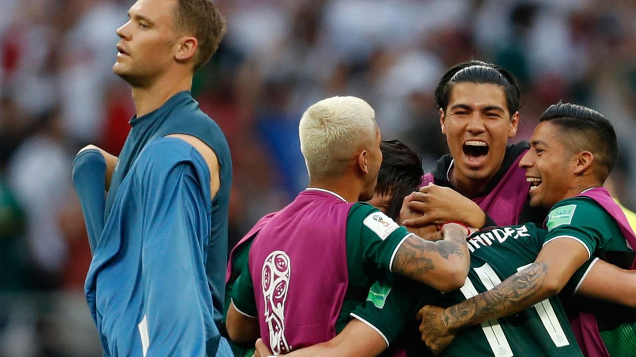Germany goalkeeper Manuel Neuer walks past as Mexico players celebrate after defeating Germany 1-0 in their group F match at the 2018 soccer World Cup on Sunday