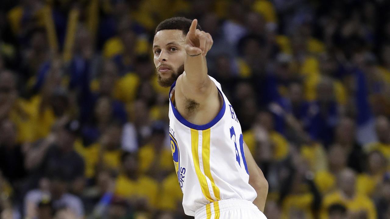 Golden State Warriors Stephen Curry signals after scoring against the San Antonio Spurs during the first half of Game 2 of the Western Conference Finals Tuesday