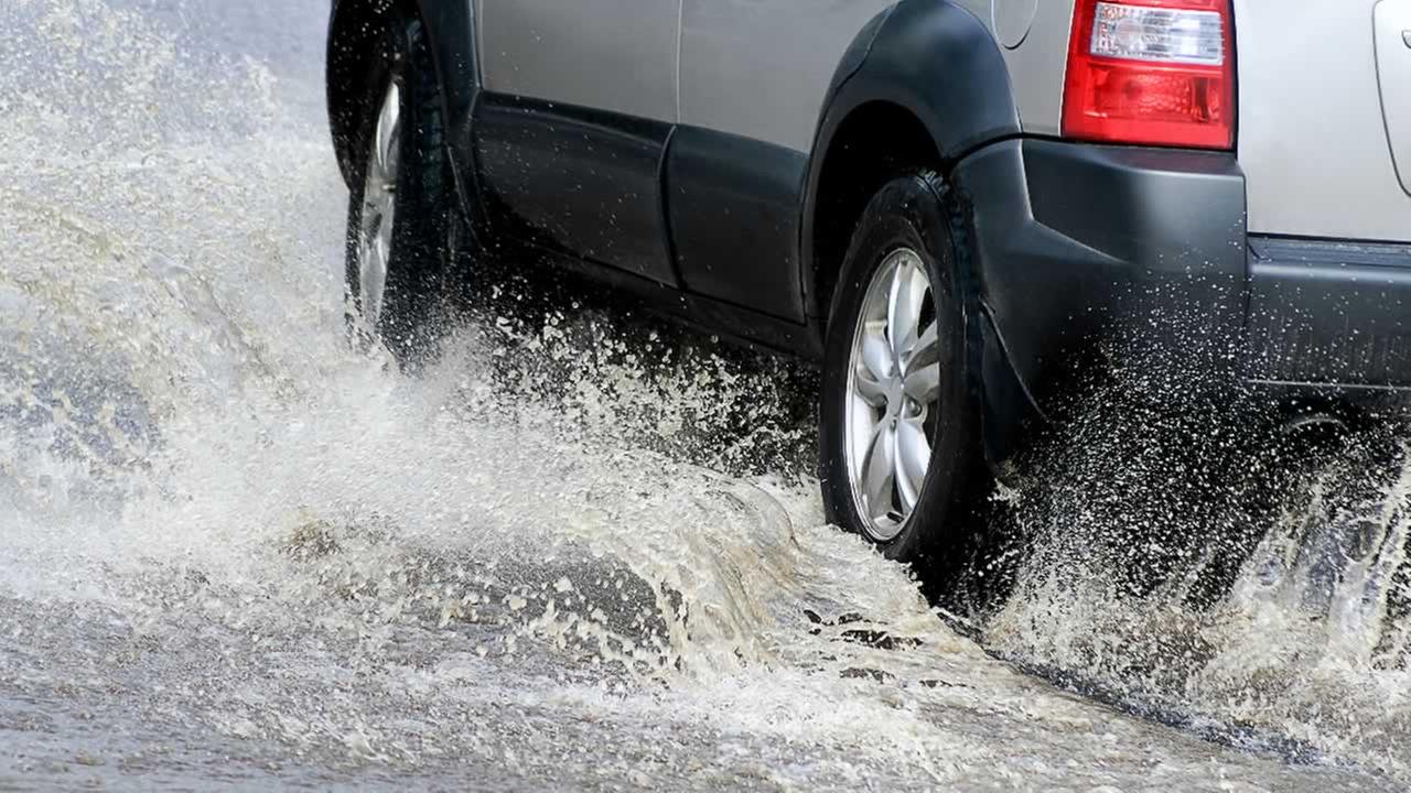 A car drives through flooded streets in this undated file photo.