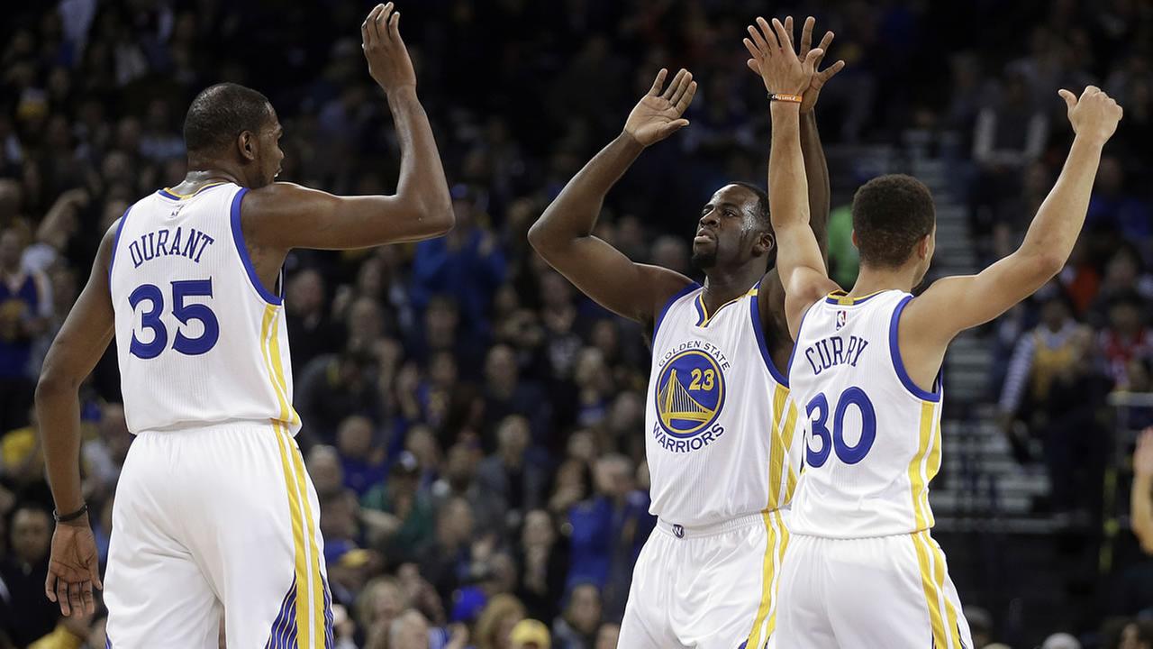 Golden State Warriors Draymond Green celebrates a score against the Houston Rockets with Kevin Durant and Stephen Curry during a game on Dec. 1 2016 in Oakland Calif