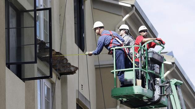FILE- In this Wednesday, June 17, 2015 file photo, a worker measures near the remaining wood from an apartment building balcony that collapsed in Berkeley, Calif.  (AP Photo)