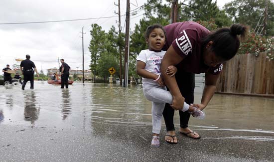 <div class='meta'><div class='origin-logo' data-origin='AP'></div><span class='caption-text' data-credit='AP Photo/David J. Phillip'>Brittany Parker puts a shoe back on her daughter Zoey after being rescued from their flooded apartment complex</span></div>