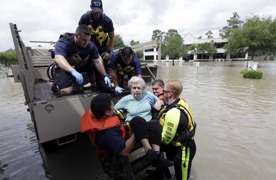 <div class='meta'><div class='origin-logo' data-origin='AP'></div><span class='caption-text' data-credit='AP Photo/David J. Phillip'>A resident of a retirement and assisted living complex is helped by rescue personnel</span></div>