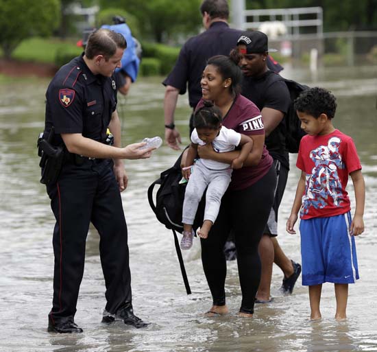 <div class='meta'><div class='origin-logo' data-origin='AP'></div><span class='caption-text' data-credit='AP Photo/David J. Phillip'>Harris County Constable Deputy J. King, left, hands a shoe to Brittany Parker as she holds her daughter Zoey</span></div>