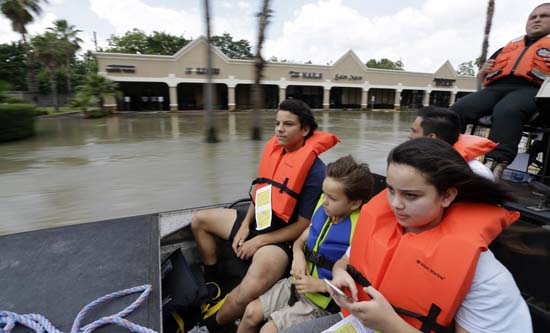 <div class='meta'><div class='origin-logo' data-origin='AP'></div><span class='caption-text' data-credit='AP Photo/David J. Phillip'>From left, Simon Holden, brother Phillip and sister Brianna ride in an airboat as they are evacuated</span></div>