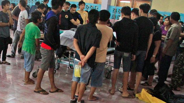 People wait to identify the bodies of their relatives among the victims of a karaoke fire, at a hospital in Manado, North Sulawesi, Indonesia, Sunday.