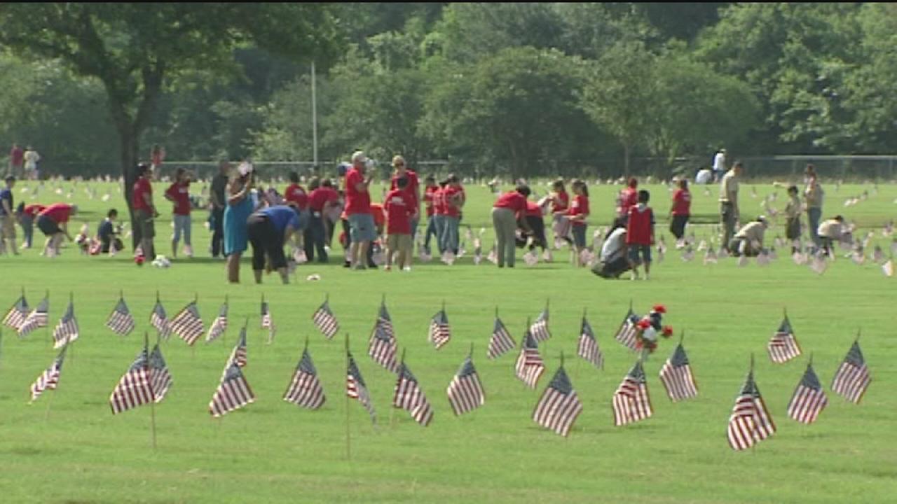 Volunteers with Flags for Fallen Vets place American flags on graves of veterans
