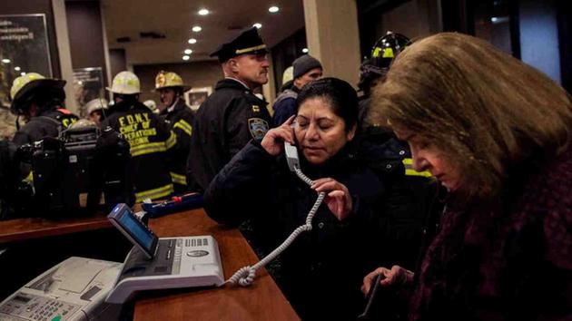 <div class='meta'><div class='origin-logo' data-origin='AP'></div><span class='caption-text' data-credit='Andres Kudacki'>Two women use the phone as firefighters and police gather in the lounge of a building after a fire there got under control on the west side of Manhattan Thursday.</span></div>