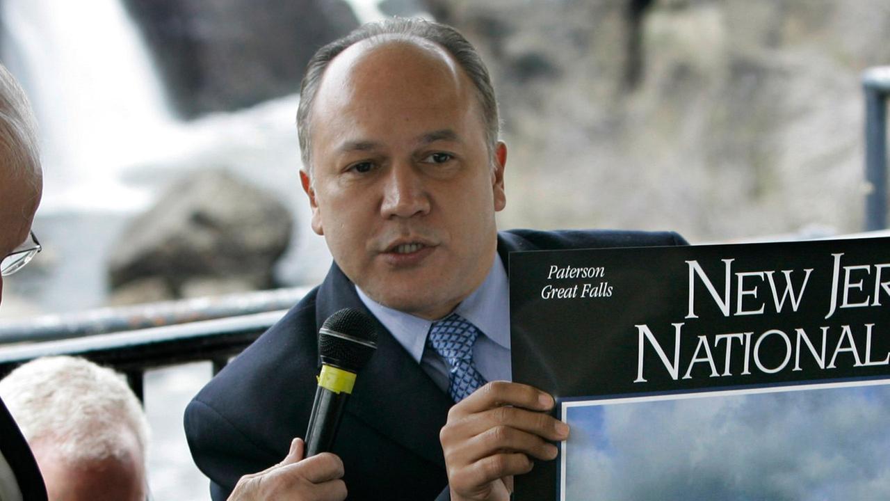 Jose Joey Torres center Mayor of Paterson N.J. holds up a National Park poster of the Great Falls during a ceremony in Paterson N.J. Wednesday