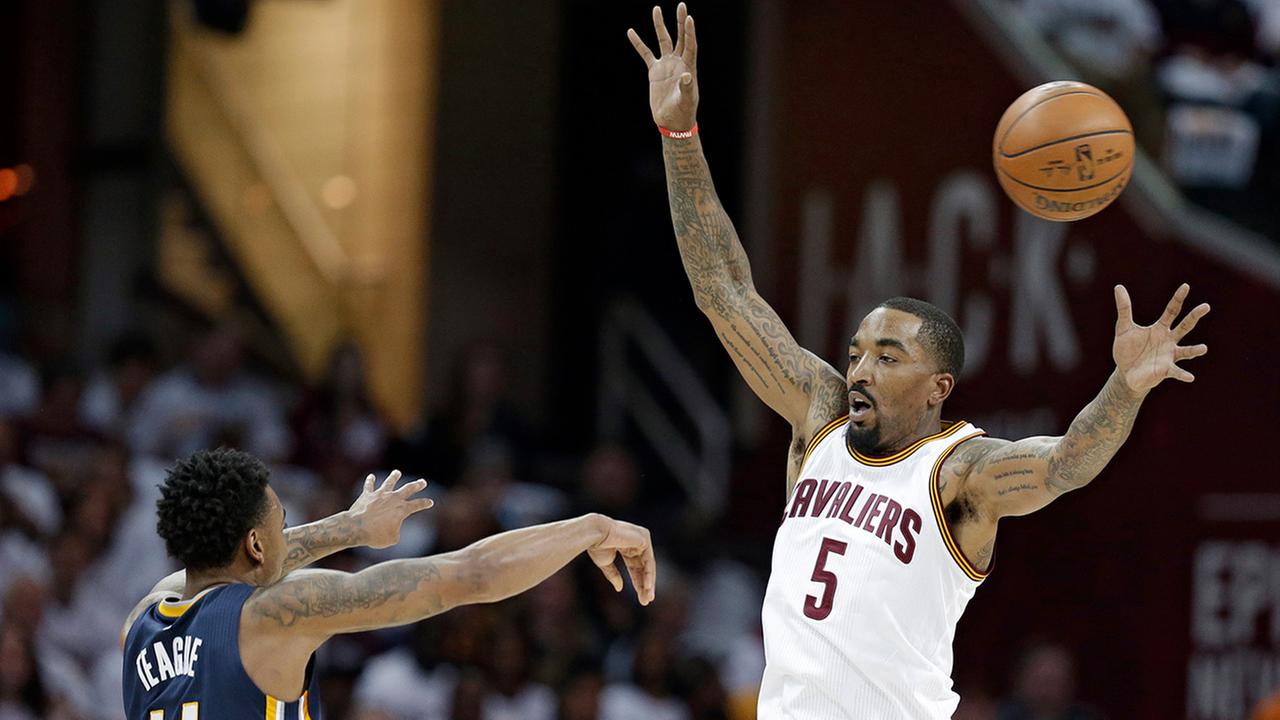 Indiana Pacers Jeff Teague passes over Cleveland Cavaliers J.R. Smith in the first half in Game 2 of a first-round NBA basketball playoff series Monday