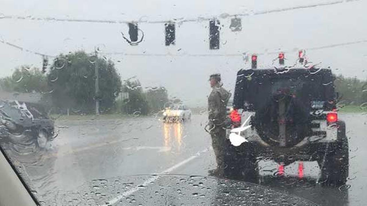 Soldier salutes funeral procession in pouring rain
