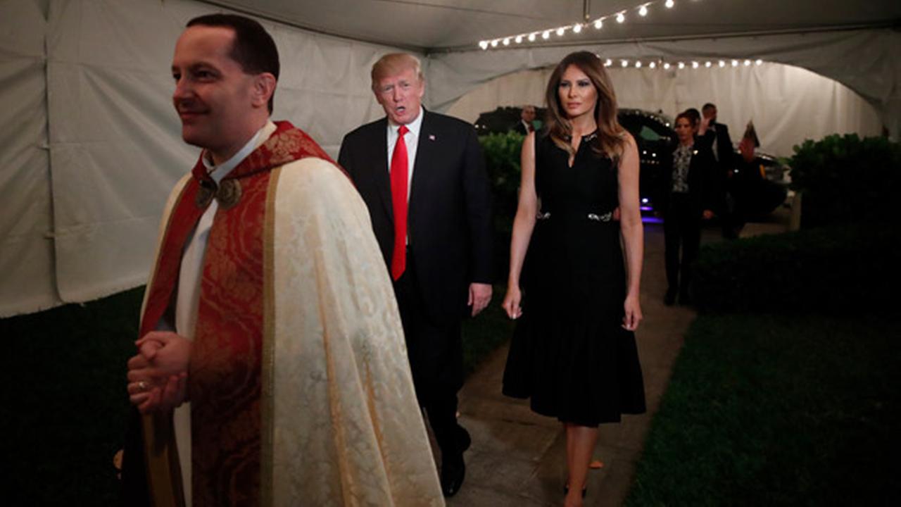 President Donald Trump and first lady Melania, escorted by Rev. James R. Harlan, as they arrive for Christmas Eve service at the Church of Bethesda-by-the-Sea in West Palm Beach.