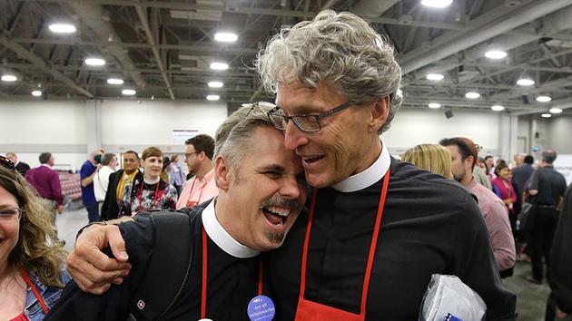 The Rev. Michael Briggs, left, and the Rev. Ken Malcolm hug after Episcopalians overwhelmingly voted to allow religious weddings for same-sex couples, July 1 in Salt Lake City.