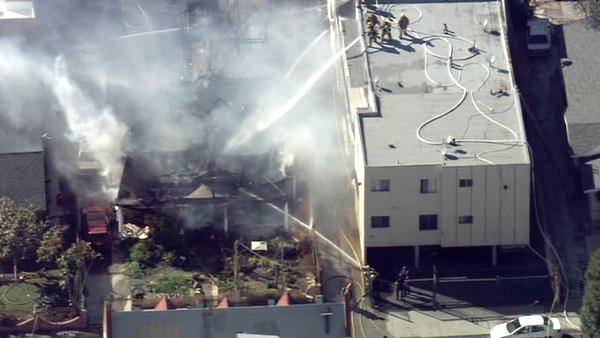 After the flames were knocked down, a body was found at the rear door of the house, according to police.