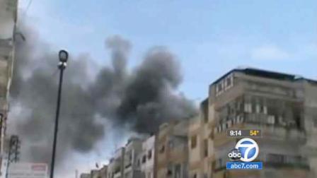 Thick smoke spews from buildings in the Syrian city of Homs in this April photo.