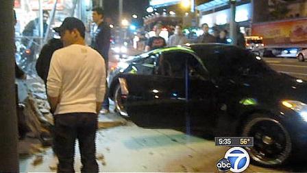 People stand at the scene of a hit and run in West Hollywood that caused major damage to a liquor store.