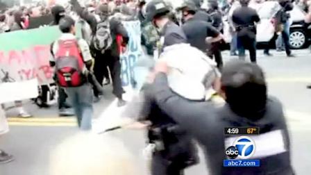A man is charged with assault and battery on an LAPD officer after she was smashed in the head during a May Day protest.