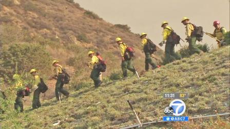 Firefighters work to put out a wildfire in the Angeles National Forest near Azusa on Tuesday, Sept. 24, 2013.