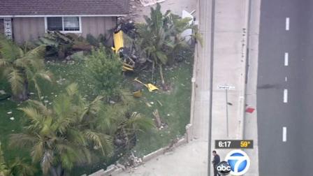 A car is seen on the front lawn of a home in Fountain Valley after the driver crashed through a brick wall at a high rate of speed, landed on the lawn and fled the scene Monday, May 21, 2012.