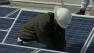 An engineers works on solar panels in this undated file photo.