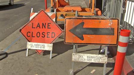 Road closure signs are seen.
