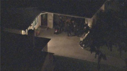 LAPD officers are seen at a home in Baldwin Village where a father was holding his 1-year-old baby in a standoff on Thursday, March 14, 2013.