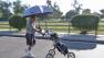 Leonard Zambito of Encino walks with his golfing gear under the protection of an umbrella on Monday, May 13, 2013. The day brought record heat to the Southland.