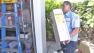 A worker carries a tankless water heater in this undated file photo.