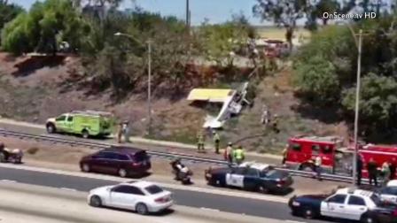 Crews are seen after a small plane made a crash landing on the shoulder of the 405 Freeway in Long Beach on Saturday, July 6, 2013.