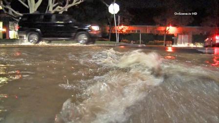 Cars drive in a street flooded by one of two water main breaks in Brentwood on Wednesday, Oct. 30, 2013.