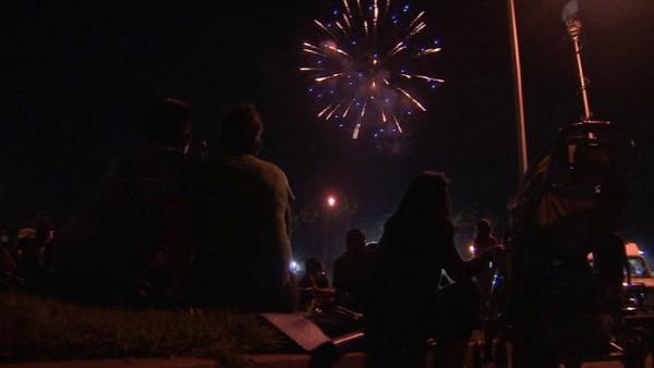 Spectators watch as fireworks light up the Rose Bowl Stadium in Pasadena, Calif. during the Americafest fireworks show on Monday, July 4, 2011.