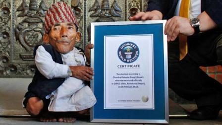 Nepals Chandra Bahadur Dangi is given a certificate by Editor-in-Chief of Guinness World Records, Craig Glanday in Katmandu, Nepal, Sunday, Feb. 26, 2012.