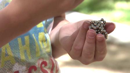 A child holds Buckyballs, the tiny, magnetic pellets intended to relieve stress, on Tuesday, July 17, 2012.
