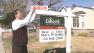 Real estate broker Chris Habitz modifies a sign on a property that was just sold on Tuesday, Jan. 15, 2013.