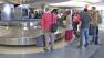 Air travelers wait for their bags at a luggage carousel at Los Angeles International Airport in this undated file photo.
