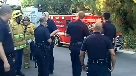 Police and firefighters are seen outside the home of Miley Cyrus on Wednesday, Aug. 1, 2012.