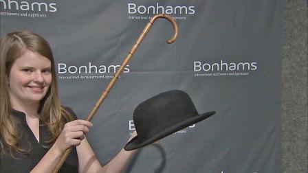 A woman is seen holding Charlie Chaplins hat and cane. The items fetched $62,500 total at an auction on Sunday, Nov. 18, 2012.