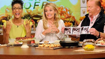 This image released by ABC shows co-hosts, from left, Carla Hall, Daphne Oz and Mario Batali holding three sonogram images, at a taping of the daytime series The Chew, on Thursday, Sept. 5, 2013, in New York.