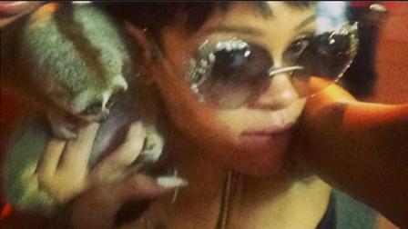 Rihanna poses with a furry primate called the slow loris, which is a protected species.